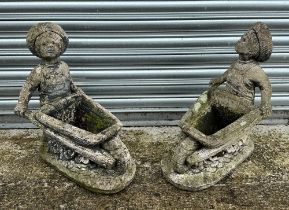 A pair of reconstituted stone planters, in the form of figures pushing barrows, each approx 20cm