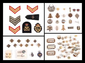 A collection of Military cap badges, buttons and cloth badges for various regiments, including Royal