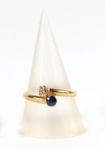 An 18ct gold, diamond and sapphire cross over ring, approx UK size P, 2.1g