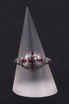 An art deco style platinum ring, set with a central diamond calibre cut rubies and further diamonds,