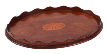 An Edwardian oval inlaid mahogany card tray, with central shell motif, 30cm wide.