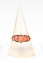 An Edwardian 9ct gold ring set, with five graduated pale pink coral cabochons, approx UK size O, 1.