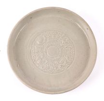 A Chinese pale celadon glazed shallow dish, decorated with dragons, 20cm diameter.