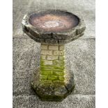 A well weathered stoneware bird bath, 61cm high.