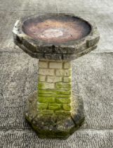 A well weathered stoneware bird bath, 61cm high.