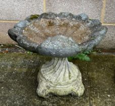 A well weathered stoneware shell form bird bath, 40cm high.