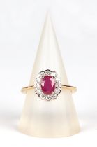 An 18ct white and yellow gold oval ruby and diamond cluster ring, ruby approx 1.02ct, approx UK size