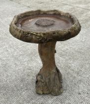 A weathered stoneware bird bath, on a naturalist column, 62cm high.