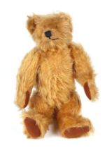 A vintage plush teddy bear, 20cm high.