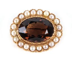 A 9ct gold brooch set with a large central stone surrounded by pearls, 3cm wide, 6.9g.