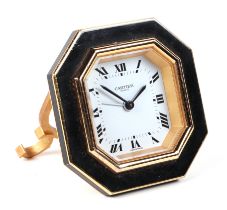 A Cartier gilt metal and black enamel table alarm clock, the white dial with Roman numerals,