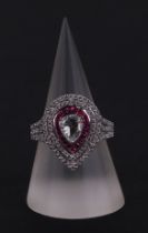 An 18ct white gold ring set with a large pear-shaped rose cut diamond, within a calibre rubies and a