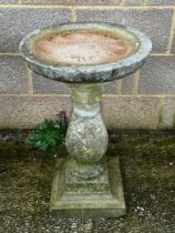 A well weathered stoneware bird bath, 69cm high.