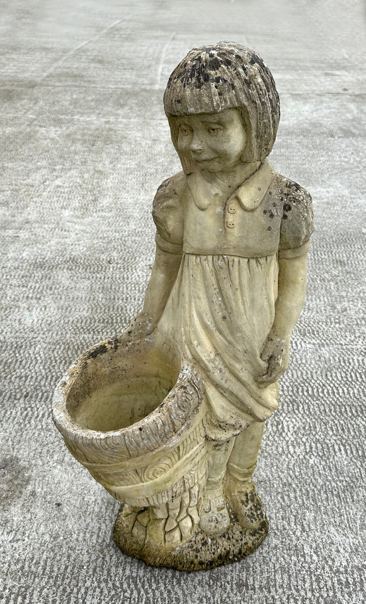 A well weathered stoneware garden ornament, depicting a young girl holding a barrel, 83cm high.