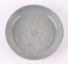 A Chinese celadon glazed shallow dish, decorated with birds and mythical beasts, 17cm diameter.