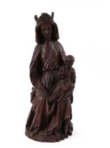 An 18th century style faux oak figural group, depicting the Madonna and Child, 42cm high.