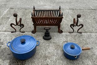 A cast iron fire grate on lion paw feet, 43cm wide; together with a pair of iron fire dogs; a cast