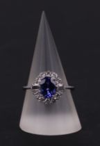 An 18ct white oval tanzanite and diamond cluster ring, tanzanite approx 1.54ct, approx UK size N