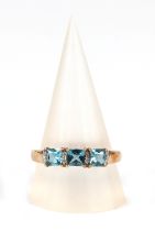 A 9ct gold ring set with three pale blue square stones interspersed with diamonds, approx UK size S.