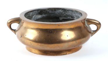 A Chinese bronze two-handled censer of compressed circular form, impressed six character mark to