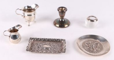 Assorted silver items including a milk jug, pin tray, dwarf candle stick, and a match strike.