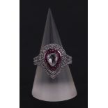 An 18ct white gold ring set with a large pear-shaped rose cut diamond, within a calibre rubies and a