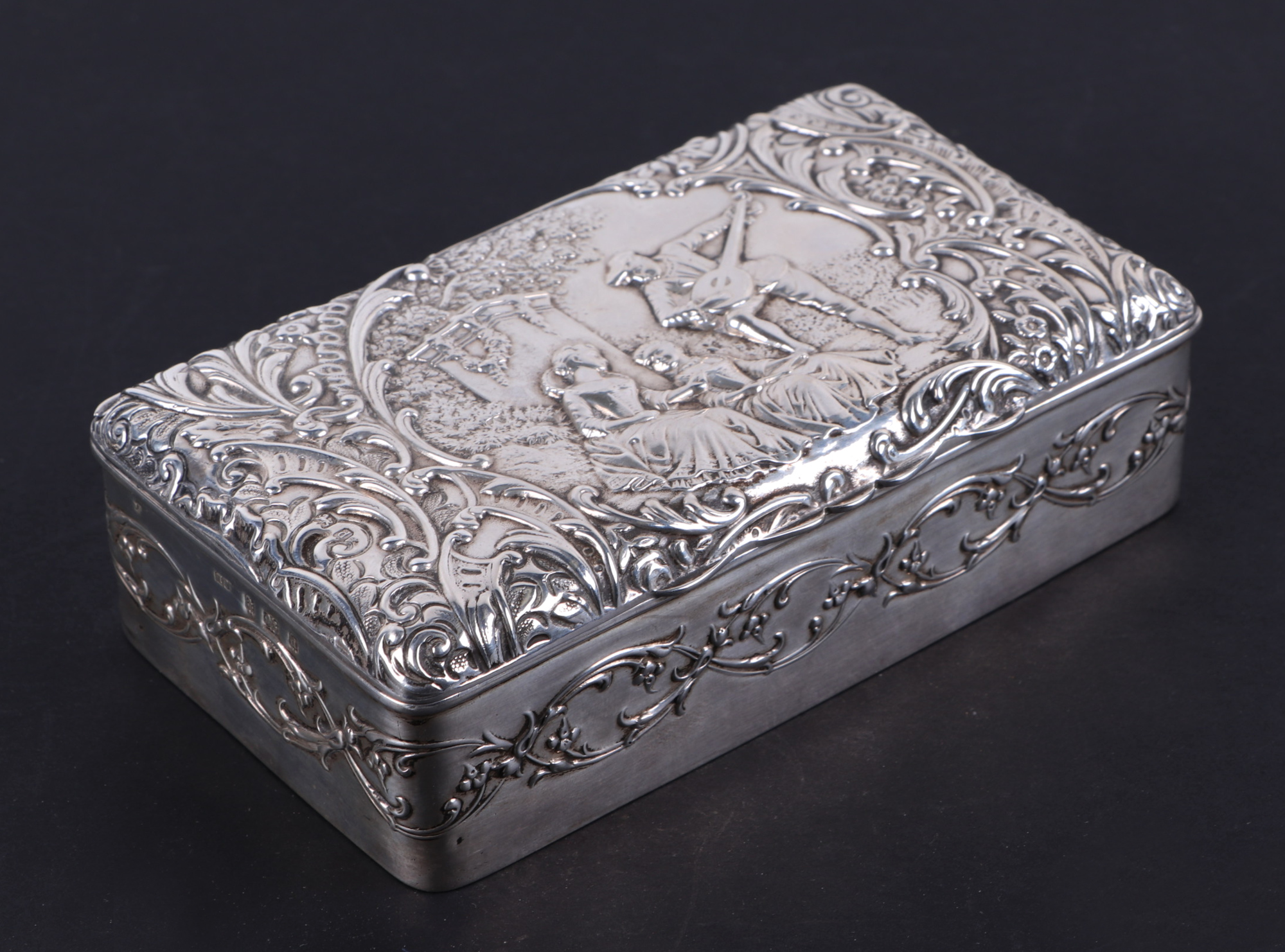 An Edwardian silver dressing table box, decorated in relief with romantic figural scene,