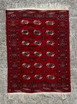 A Caucasian rug with repeating guls on a red ground, within a multi geometric boarder, 102 by