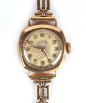 A 9ct gold ladies wrist watch, on a rolled gold strap.