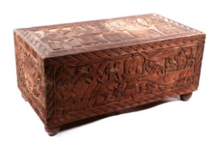 A Benin carved hardwood trunk profusely carved with figures and hunting scenes, 86cm wide.