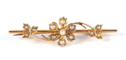 A late 19th century 15ct gold bar brooch, with central seed pearl set flower and leaves, 4cm wide,