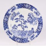 A 20th century Japanese blue and white charger, decorated a fir tree in a landscape, 42cm diameter.