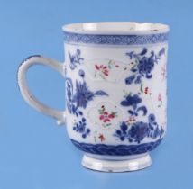 An 18th century blue and white mug, decorated flowers and insects, 12cm high (af).
