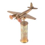 A trench art cast brass model of a Mosquito aircraft, mounted on a brass plinth, wingspan 20cm.