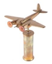 A trench art cast brass model of a Mosquito aircraft, mounted on a brass plinth, wingspan 20cm.