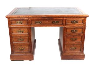 A late 19th pedestal desk, rectangular top with green inset leather, above an arrangement of nine