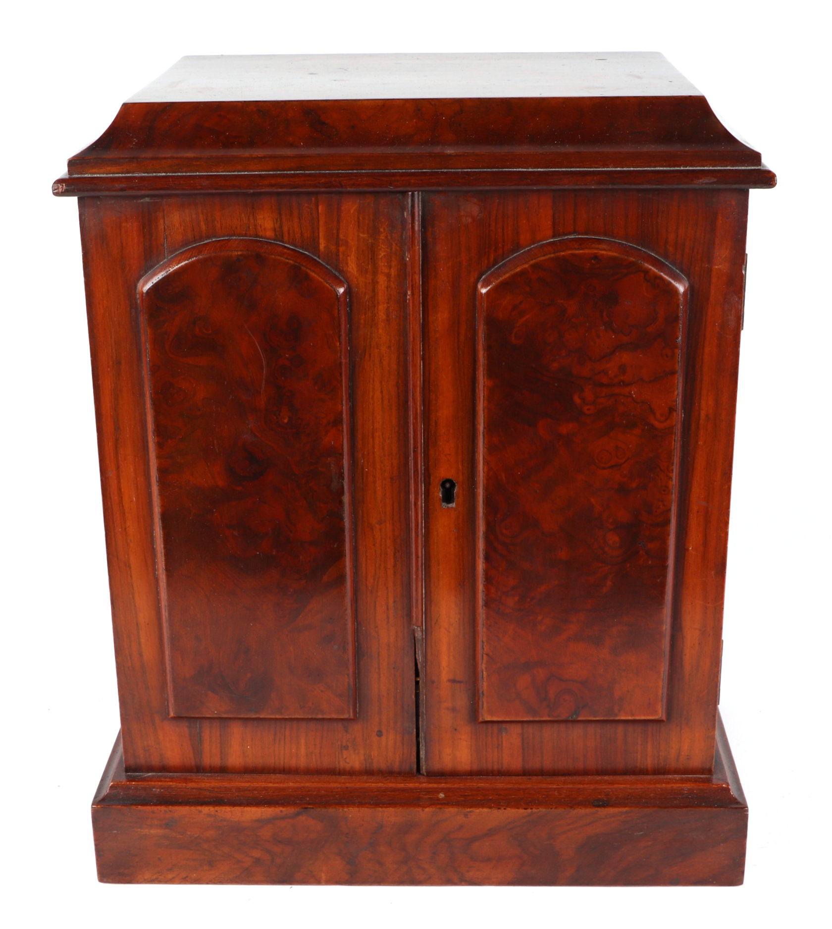 A Victorian figured walnut table top cabinet, the pair of doors enclosing three drawers, standing on