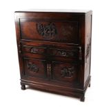 A Chinese hardwood writing cabinet, with carved panels, the full front enclosing fitted interior