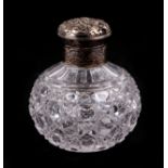 A white metal topped cut glass scent bottle of globular form, 11cm high.