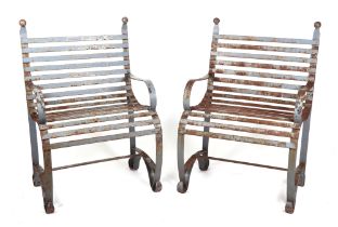 A pair of well weathered heavy iron strap work chairs, with scroll arms and feet, 67cm wide (2).