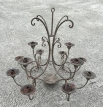 A 12 branch wrought iron celling candelabra, together with two matching three branch wall sconces,