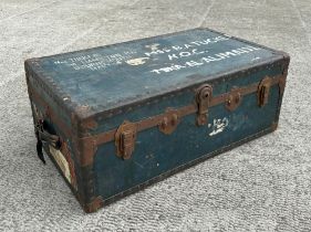 A vintage travel trunk, with reinforced corners, leather carrying handles and a selection of luggage