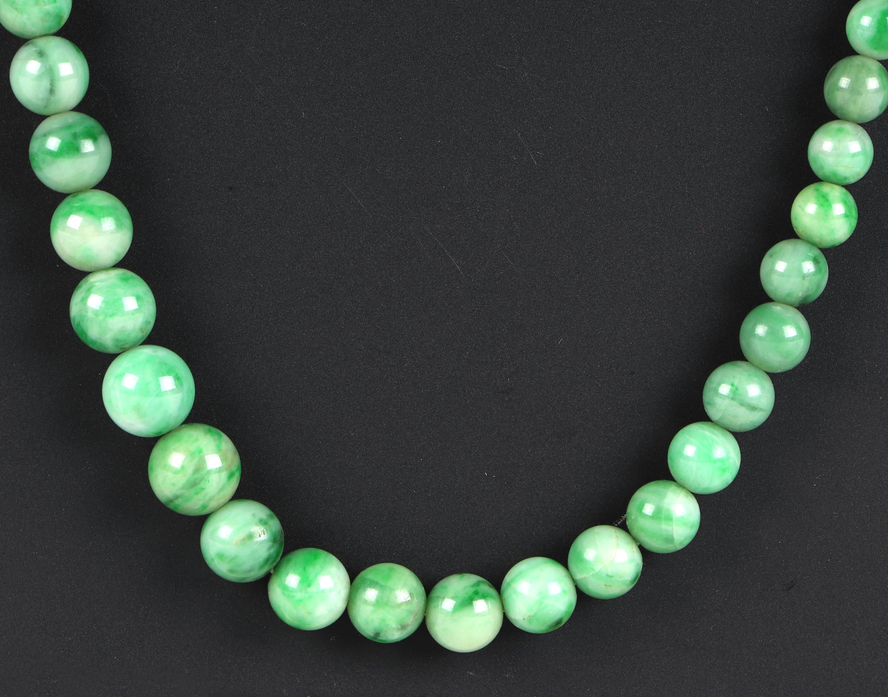 A Chinese graduated apple jade bead necklace, approx 64cm long. Condition Report A crack to one - Image 2 of 7