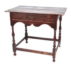 18th century oak side table, having a single frieze drawer above a shaped apron, on baluster