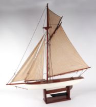 A pond yacht, having a painted hull, 72cm long, mounted on a stand.
