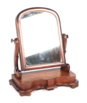 A Victorian mahogany toilet mirror, having an arch rectangular plate, on scroll supports, and