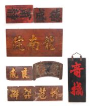 A Shanghai carved and gilded teak shop front sign, 133 by 66cm, three smaller signs, a three part