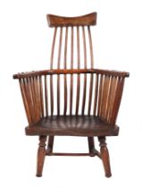 A late 18th century Welsh primitive comb-back open armchair with solid elm seat, on turned front