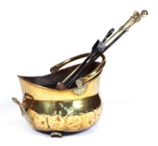 A brass cauldron form coal bucket, on paw feet, with a selection of fire side implements.