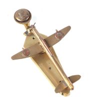 A trench art cast brass small aeroplane modelled as a door knocker, wingspan 10cm.